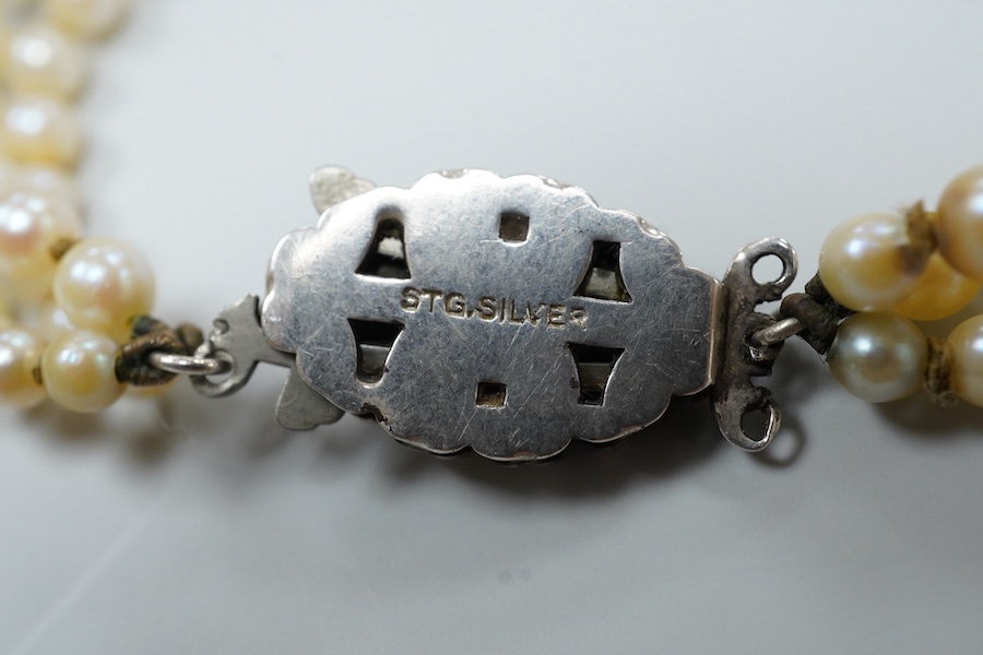 A triple strand graduated cultured pearl necklace, with marcasite set sterling clasp(a.f.), approximately 38cm.